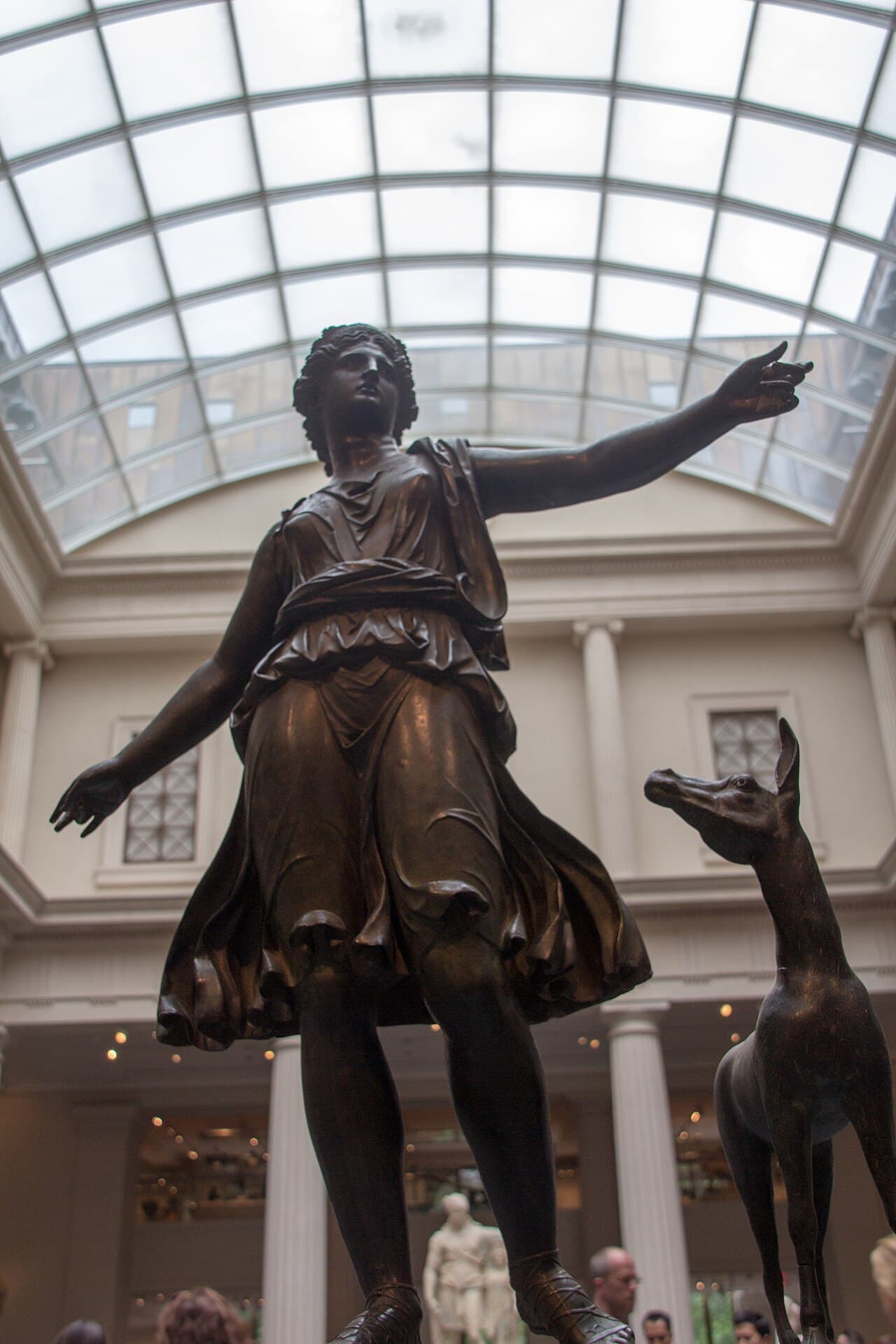 Bronze statue of Artemis standing beside a deer
